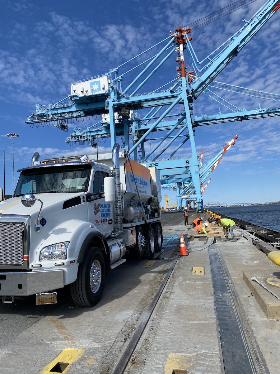 Concrete on Demand truck parked on a dockside pour site with crew working nearby