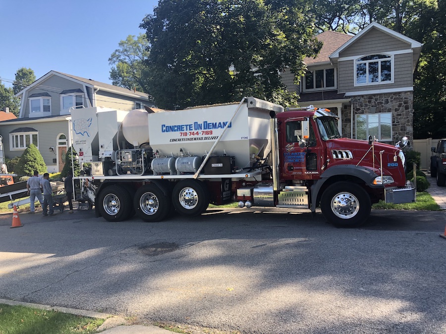 Mixer truck delivering concrete on a residential street driveway