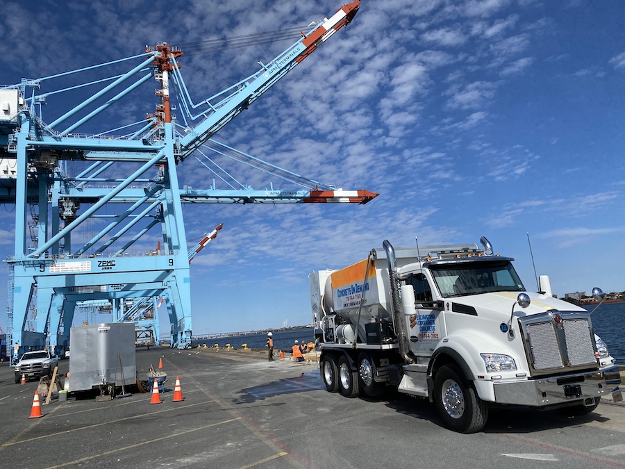 Concrete on Demand mixer truck at a port terminal pour beside container cranes